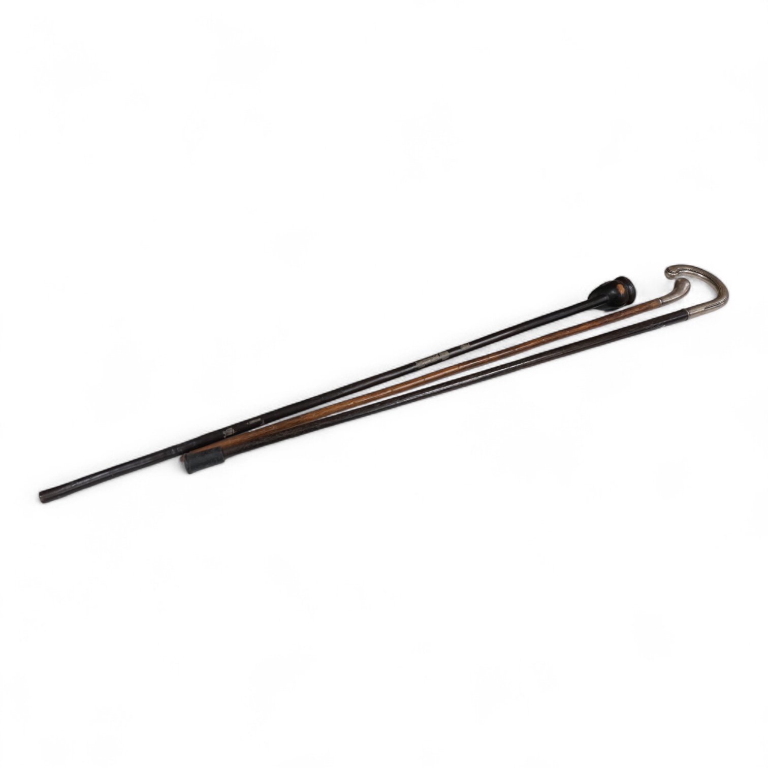 Two silver mounted walking sticks and a tribal carved ebony walking stick, longest 93cm